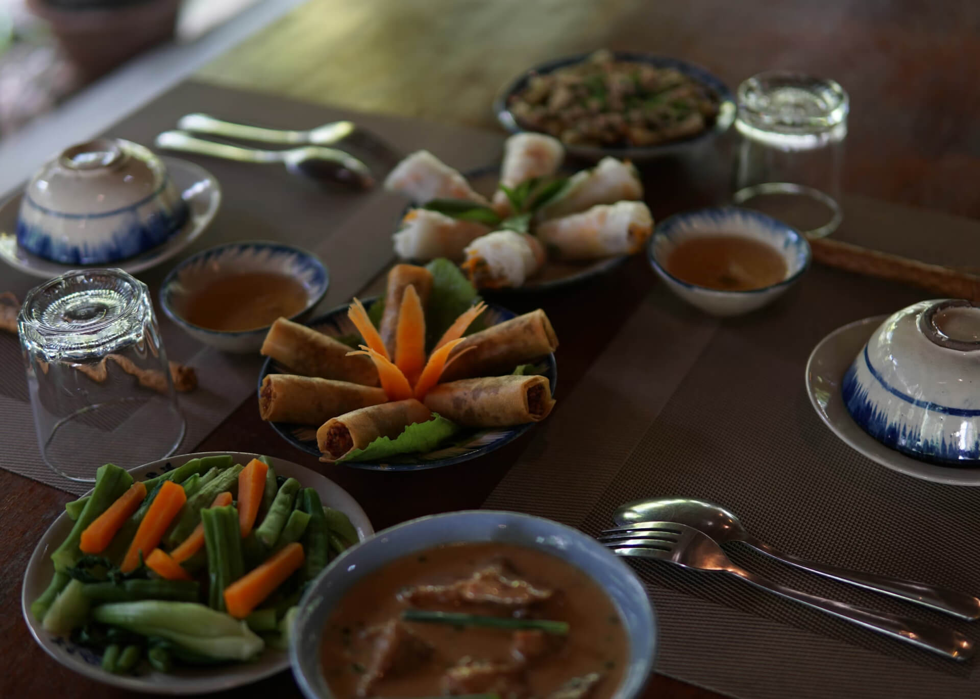Indonesian appetizer spread with spring rolls and dipping sauces